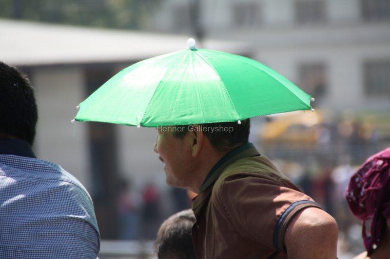Mann mit aufgespanntem Sonnenschirm auf Kopf