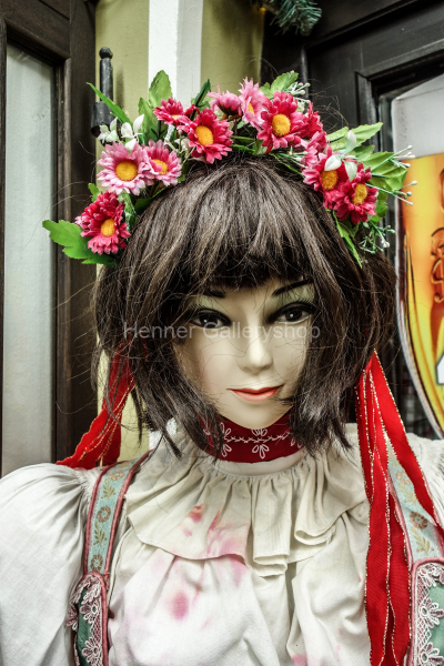 Schaufensterpuppe mit langen dunklen Haaren und Blumenschmuck