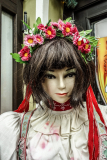 Schaufensterpuppe mit langen dunklen Haaren und Blumenschmuck