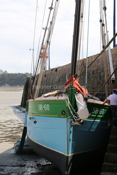 Fischerboot bei Ebbe auf Grund in Hafen